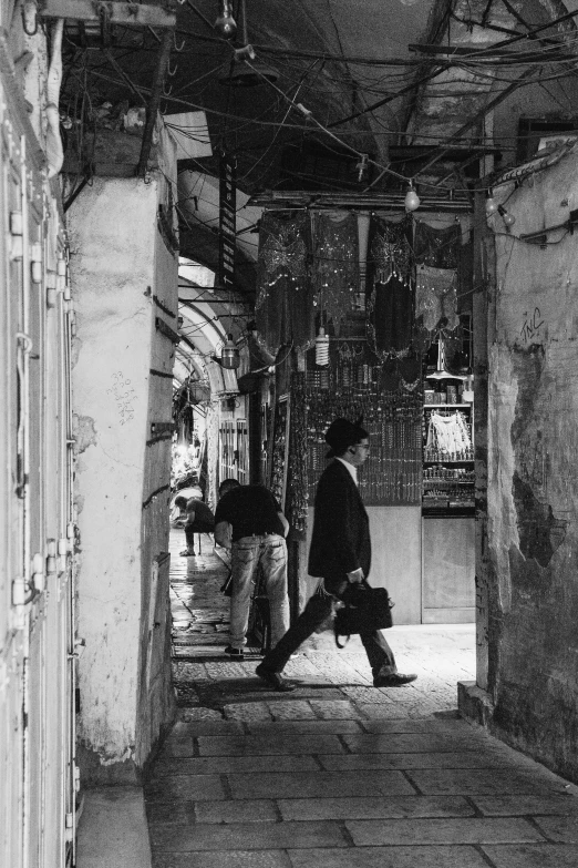 black and white pograph of man in alley way