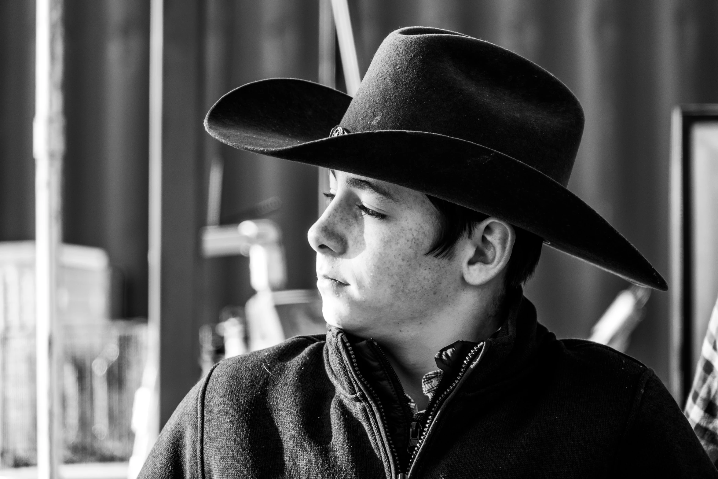 a young man with a cowboy hat looking to his left