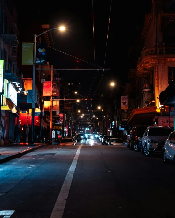 the cars are parked in the dark on the side of the street