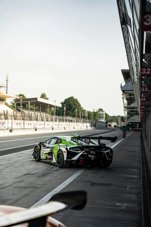 the car drives around the track, close to the fence