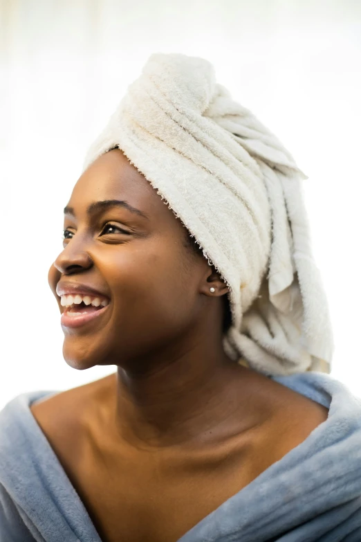 a woman with a towel on her head smiles