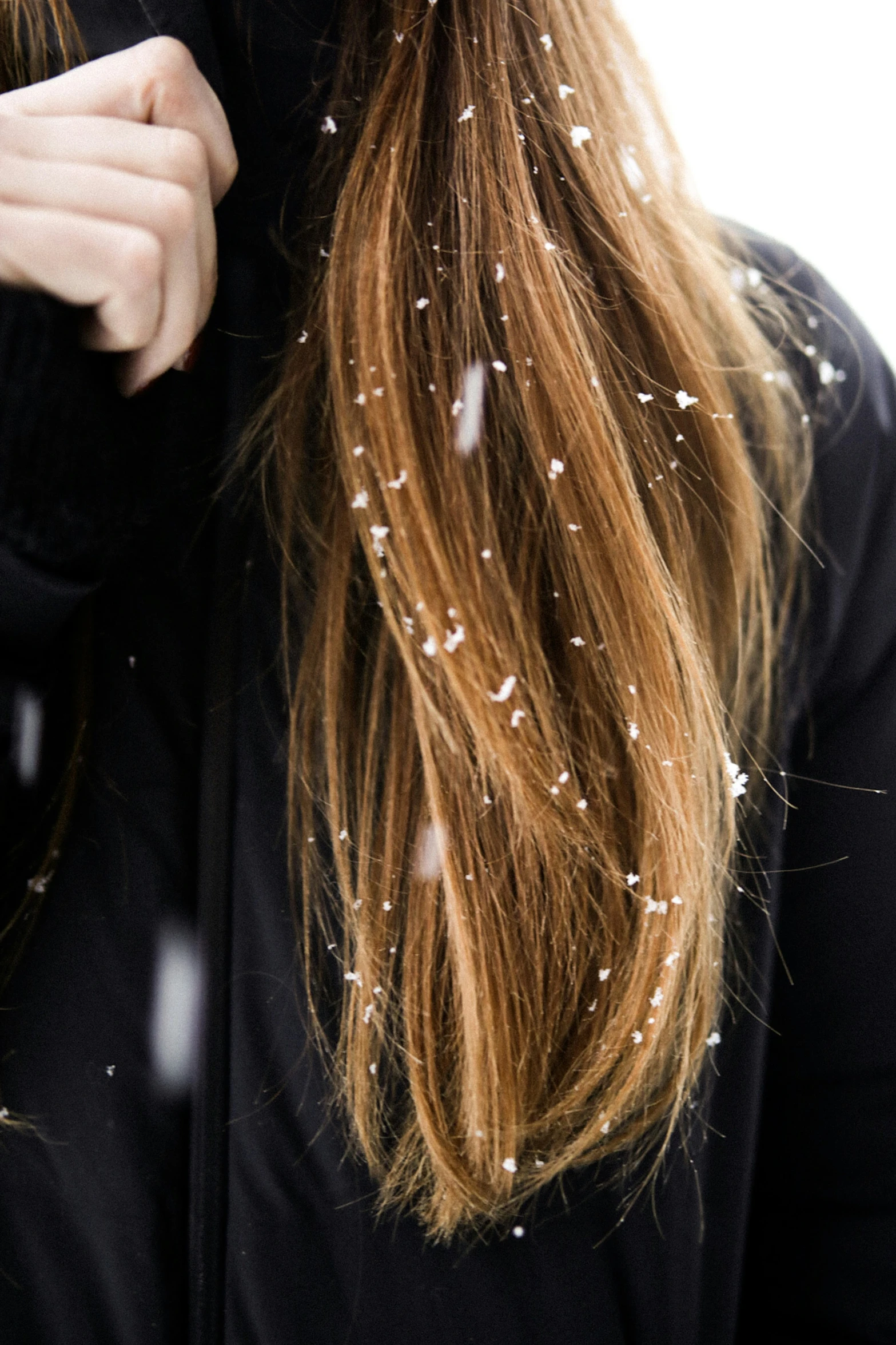 a woman wearing black is covering her long hair with white dots