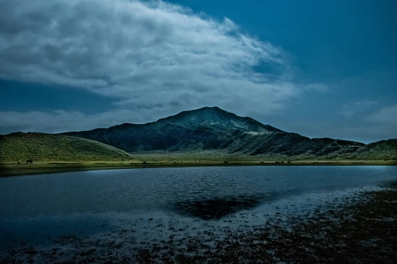 the water and mountains in the distance at night