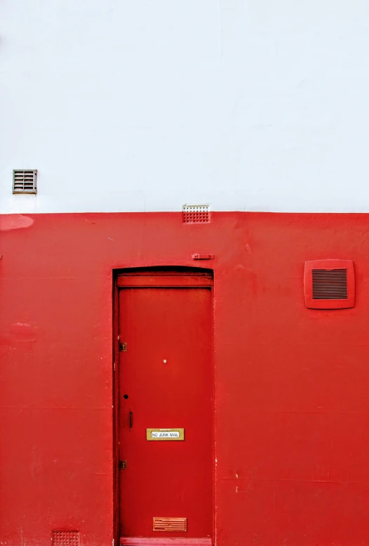 a red door and window on a white wall