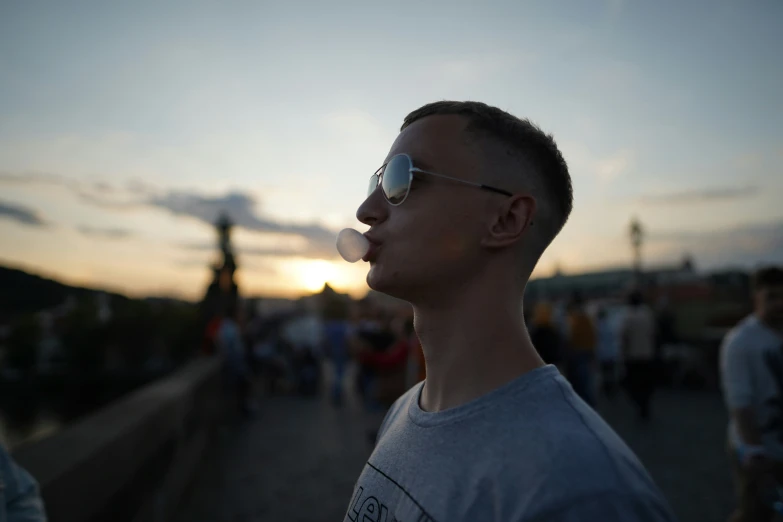 a man blowing soap into his mouth at sunset