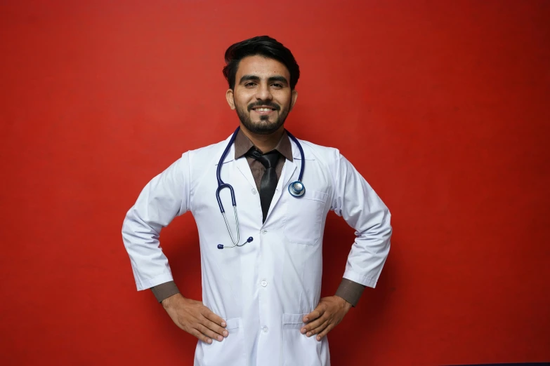 a smiling man is standing in front of a red wall