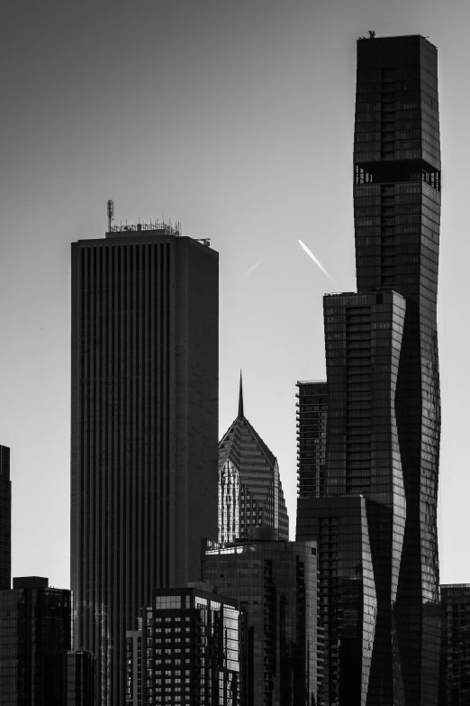 a black and white po of skyscrs with a plane in the background