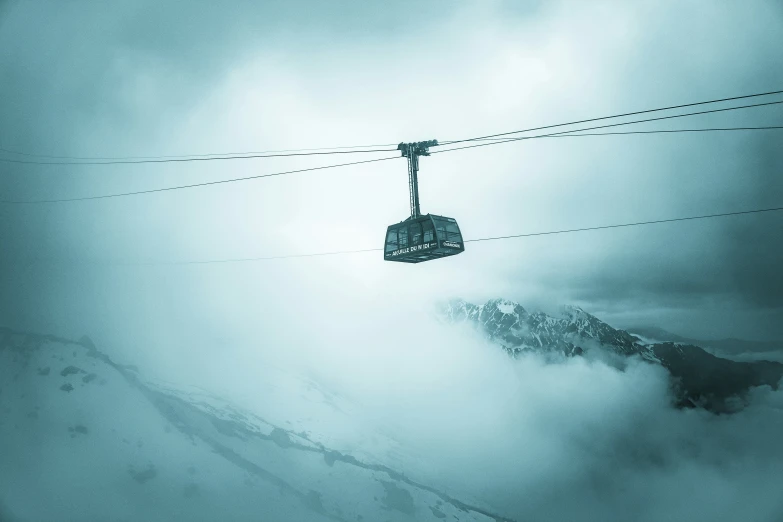 a ski lift is being lifted by mountains in the background