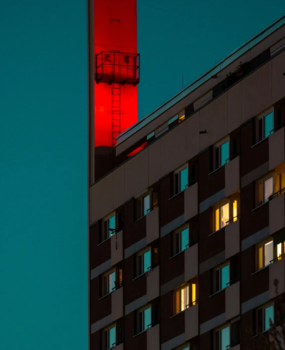 a red tower light up the sky and the building at night