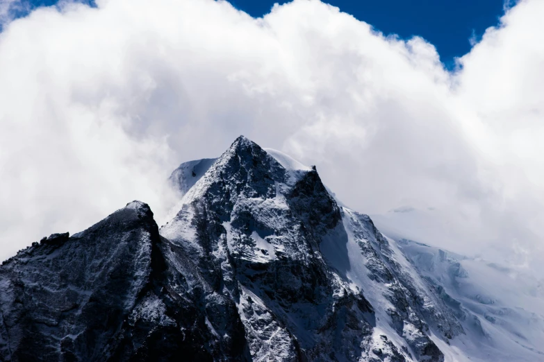 the summit of a mountain is covered by clouds