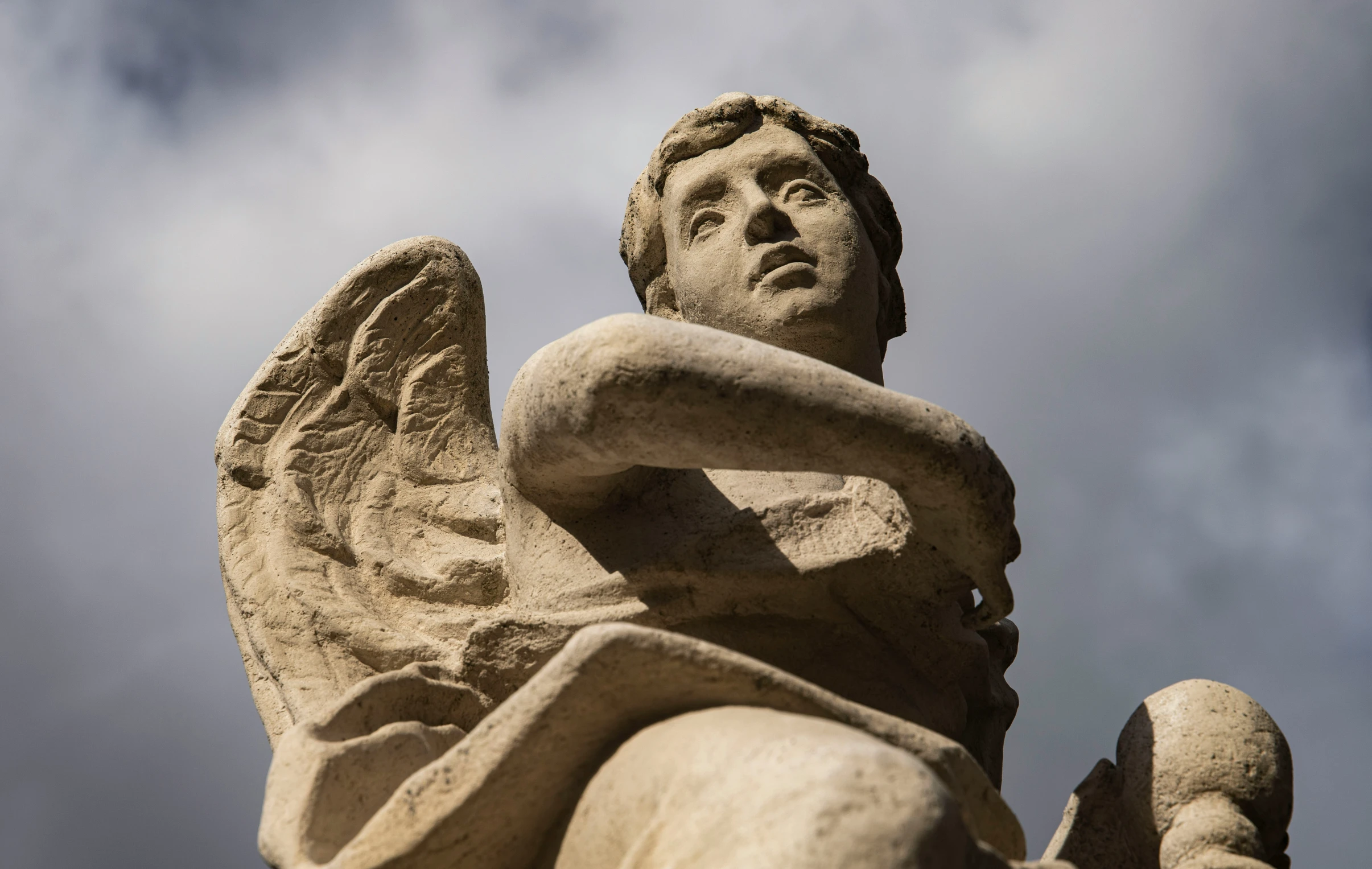 a statue of a winged angel that appears to be in front of a blue sky