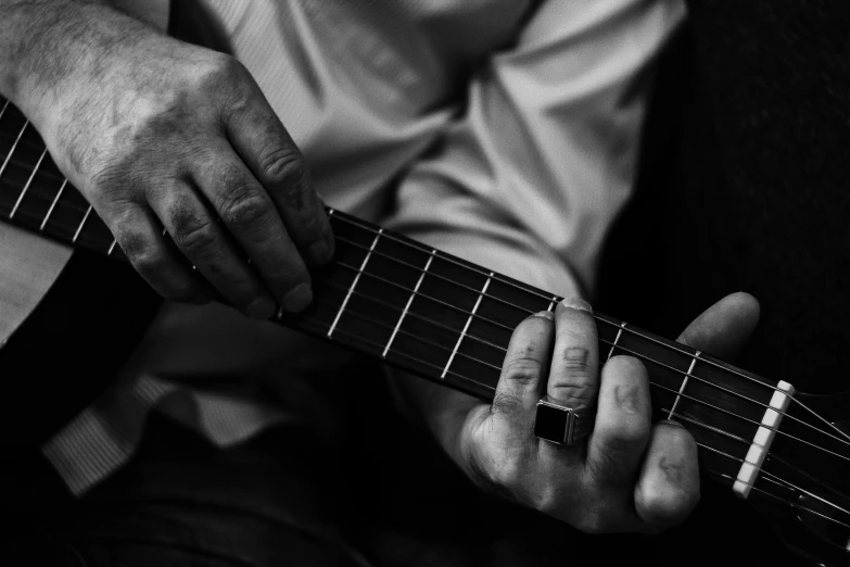 a man playing guitar while he is wearing jeans