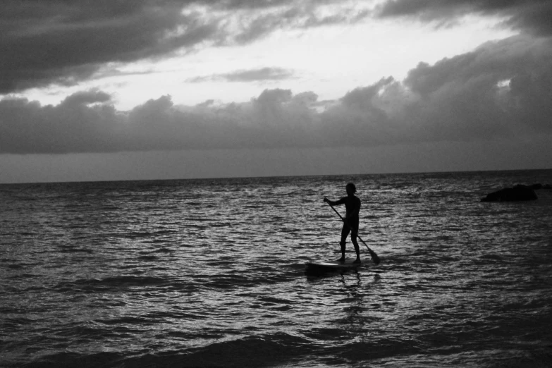 a man standing on his surfboard in the middle of water