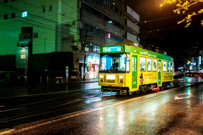 a yellow bus driving down a city street at night