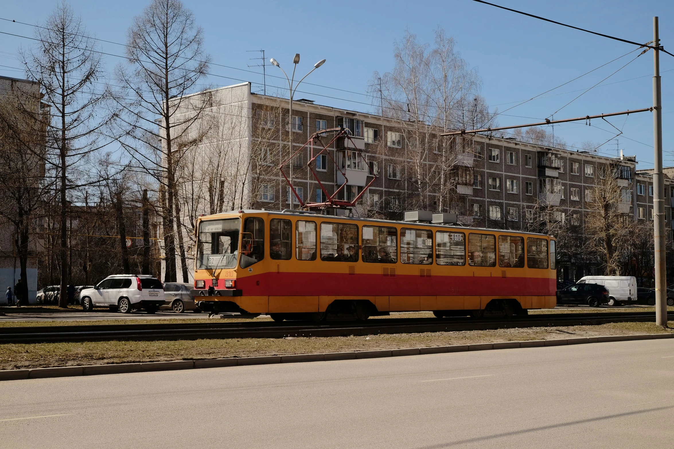 an orange and red trolley car in the middle of a road