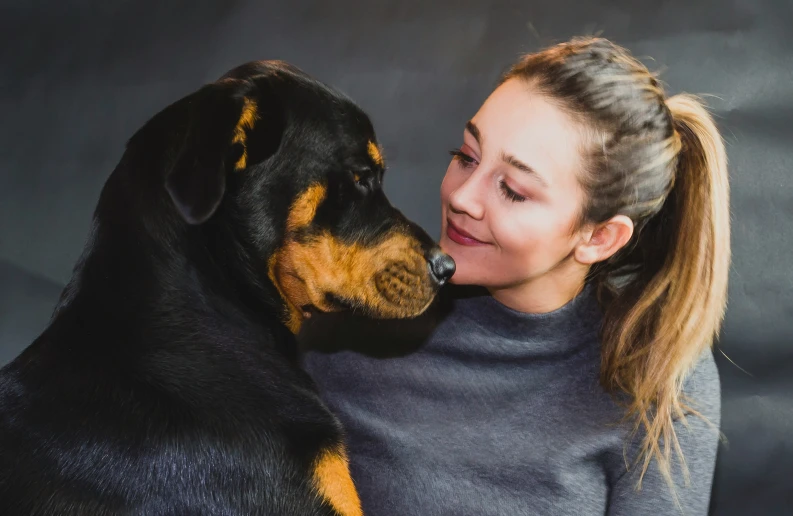 the woman is hugging her dog outside with a serious look on his face