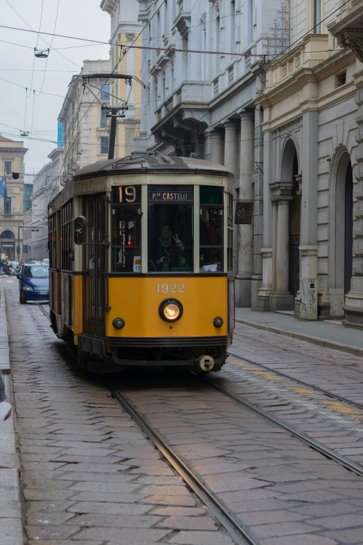 an orange trolley train on its tracks through the city