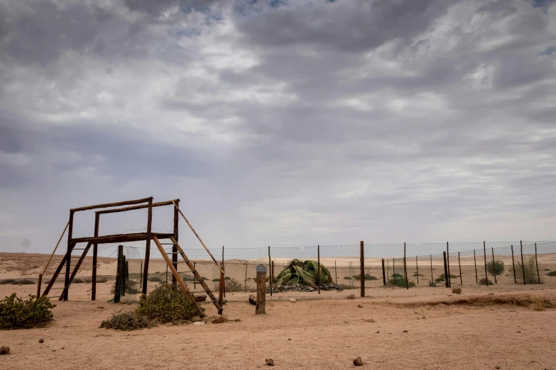 an old wooden structure in the middle of the desert