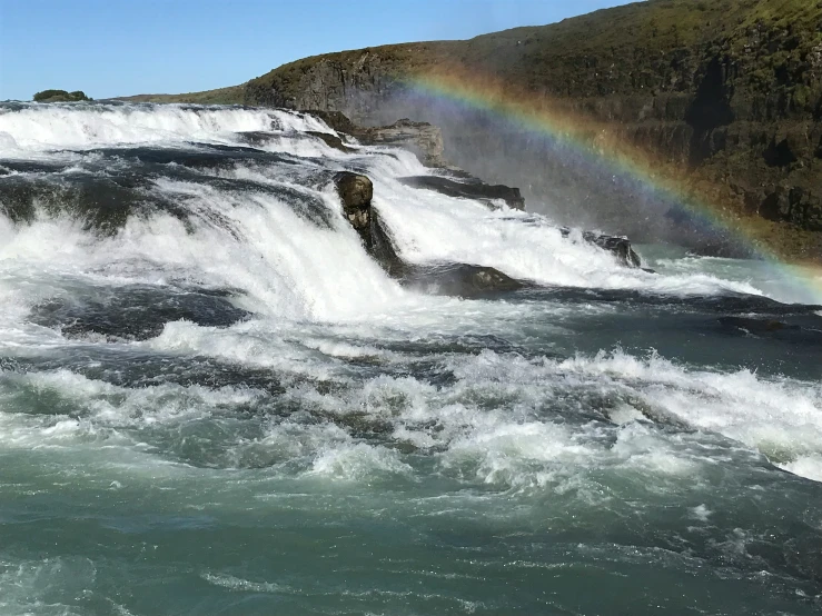 a waterfall, the end of a rainbow as it is raining