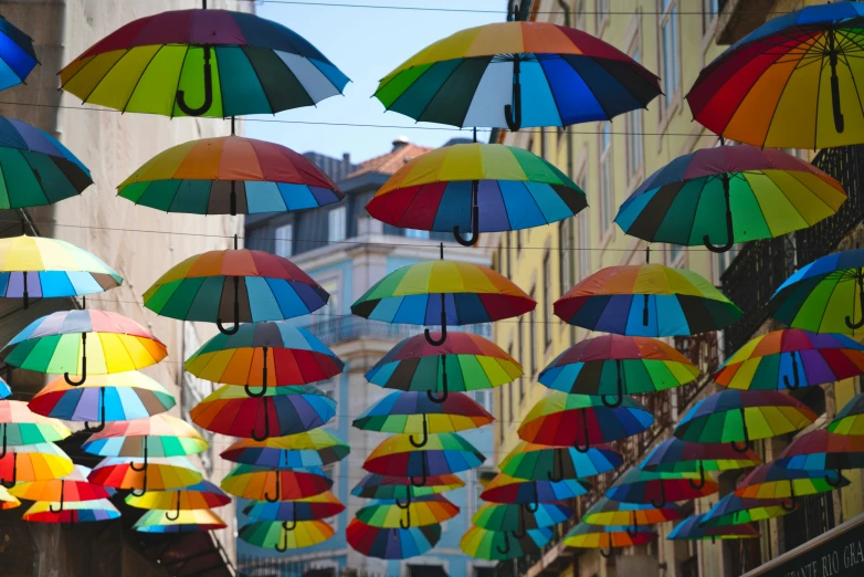 a street lined with multicolored umbrellas suspended from the ceiling