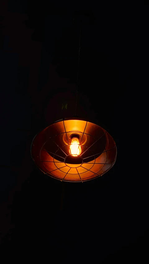 an orange light is suspended on a black background