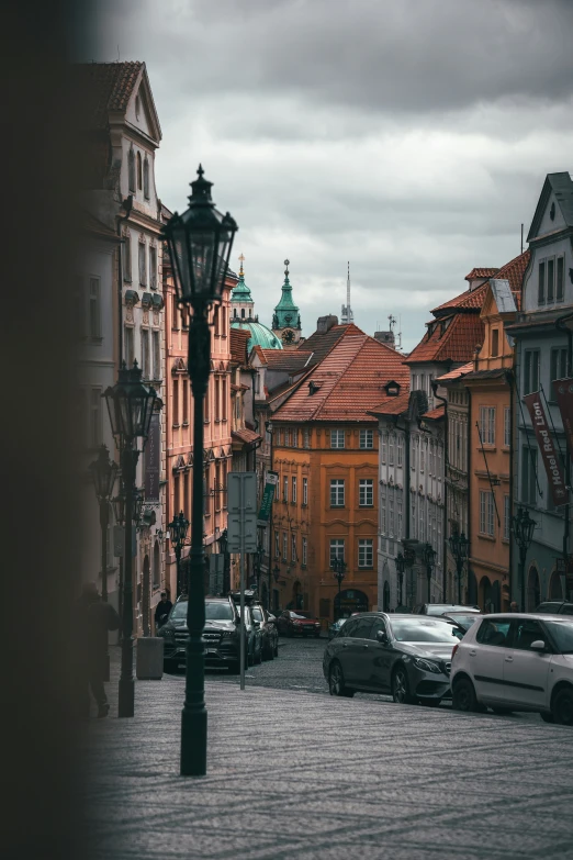 a cobblestone street lined with parked cars