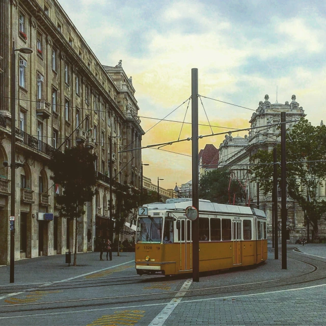 an orange tram traveling down a street past tall buildings