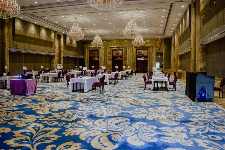 a large ballroom is set up with purple, white and blue tables