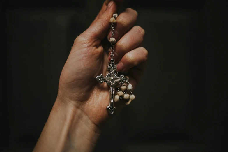a person is holding a rosary together