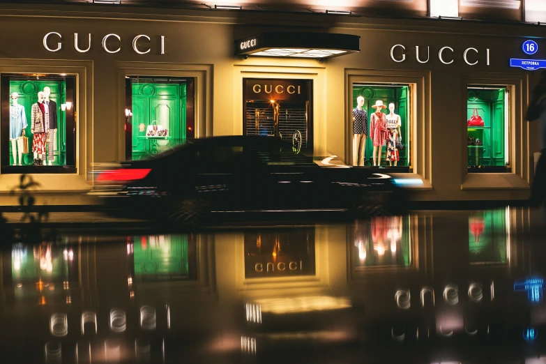 a black car in front of a building with window reflections