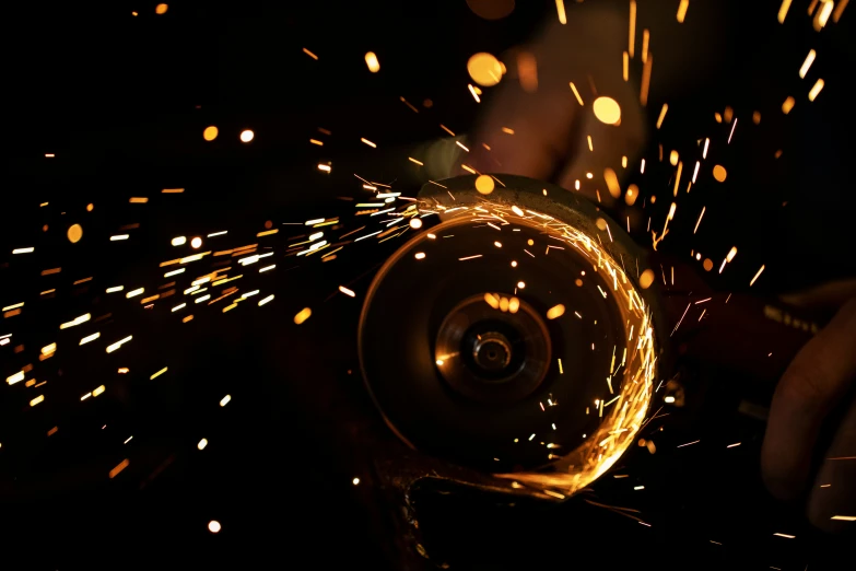 a grinding machine being held in motion with sparks