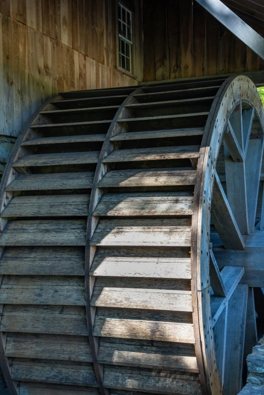 an old wooden spinning wheel is by some wood