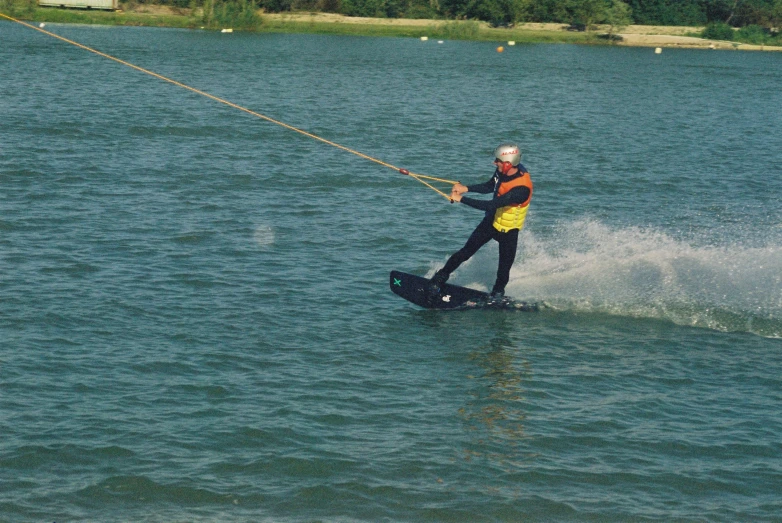 a man water skiing on the ocean near green grass