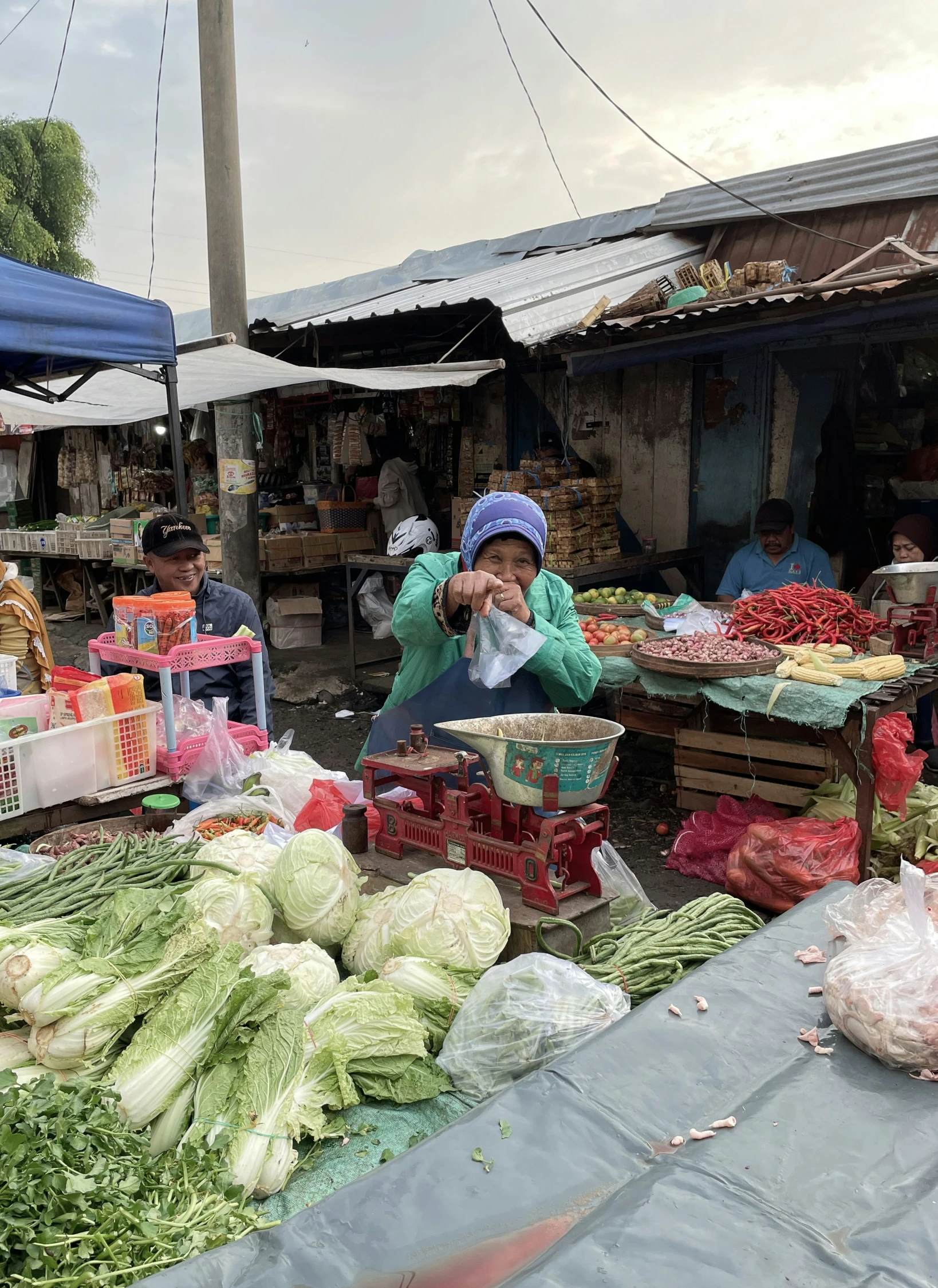 a woman at an outdoor fruit and vegetable stand