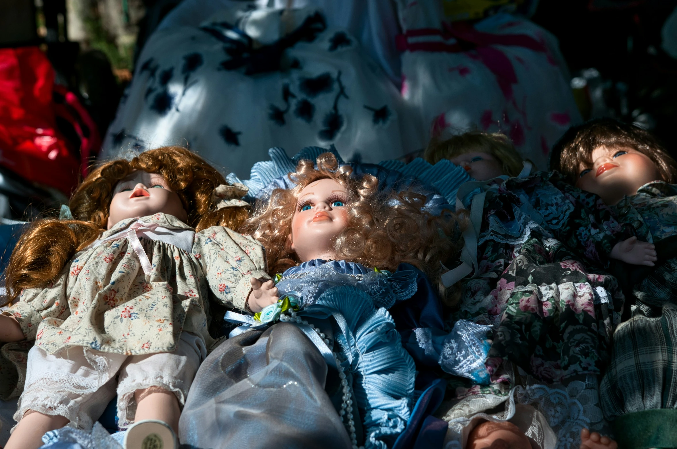 many old fashioned dolls are sitting in the ground