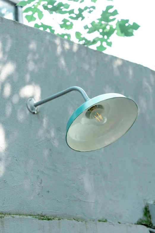 an outdoor lighting fixture in front of a wall