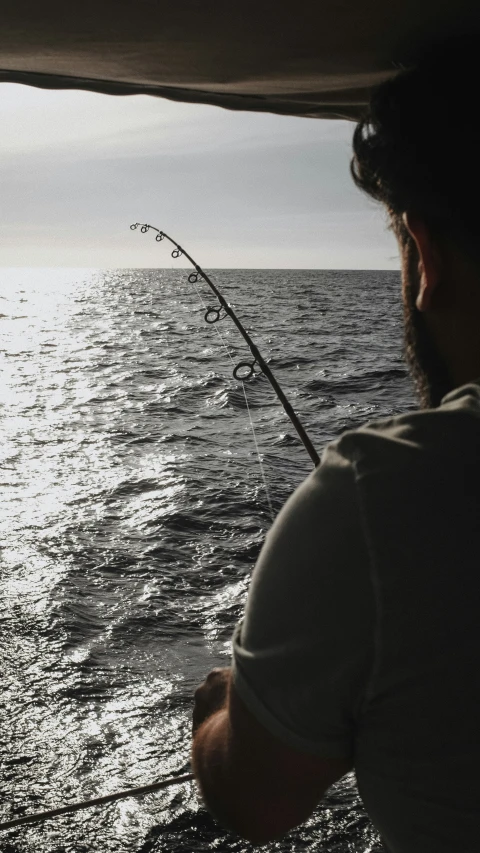 the man is fishing in the water with his rod