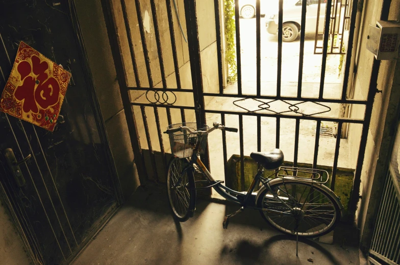 bicycle locked outside an iron gated area with a sign