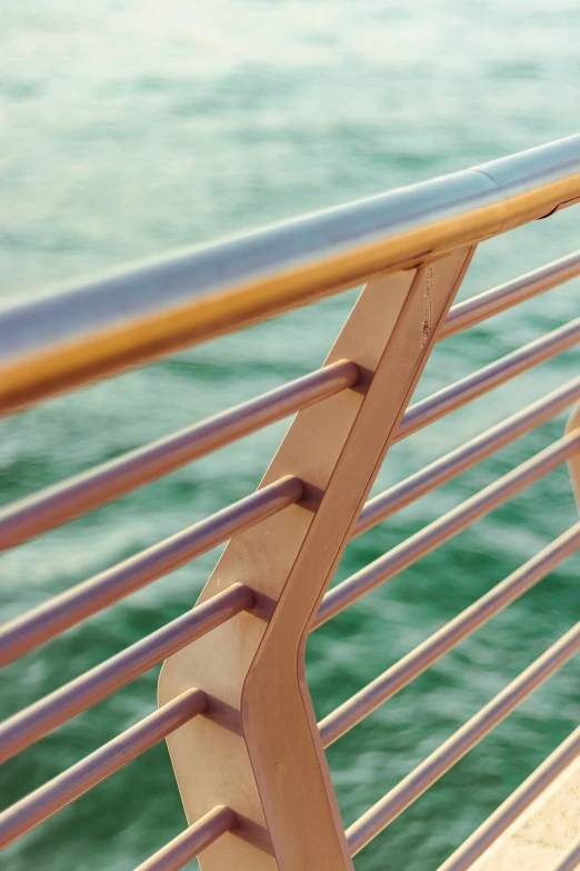 a brown wooden bench next to the ocean