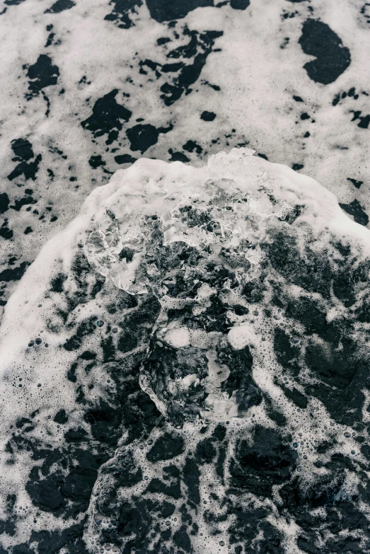 an ocean shore view with white foam on the water