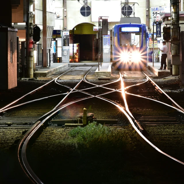 the train is moving around the tracks in the dark