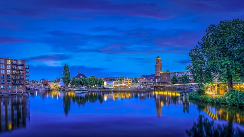 a lake is lit up at night next to buildings