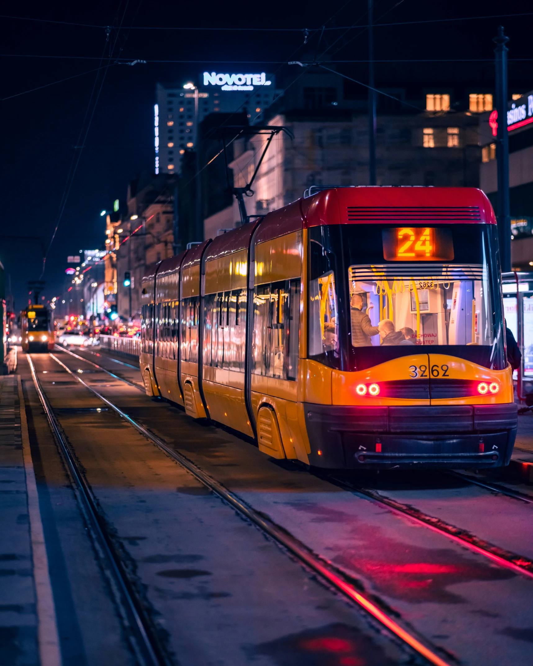 a public transit train rides through the city at night