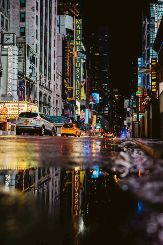 there are cars driving down this street in the rain