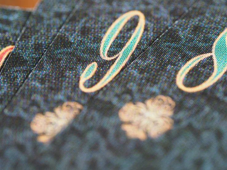 a close up view of a blue fabric with gold letters