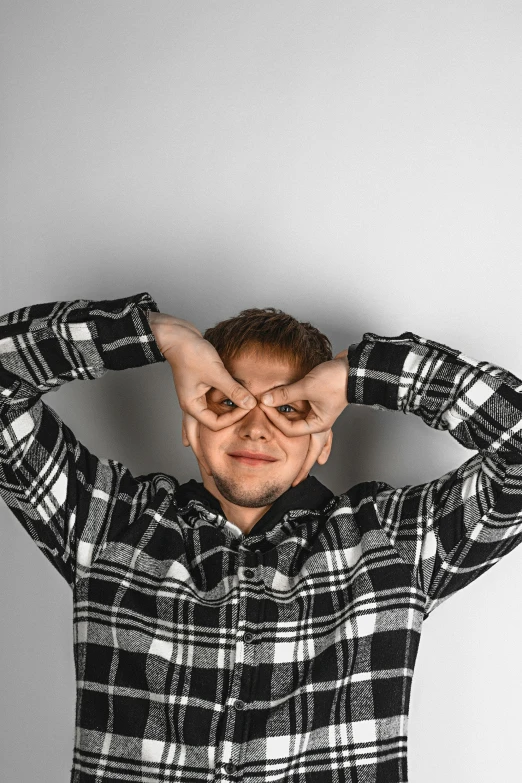 a man with glasses covers his eyes in front of him