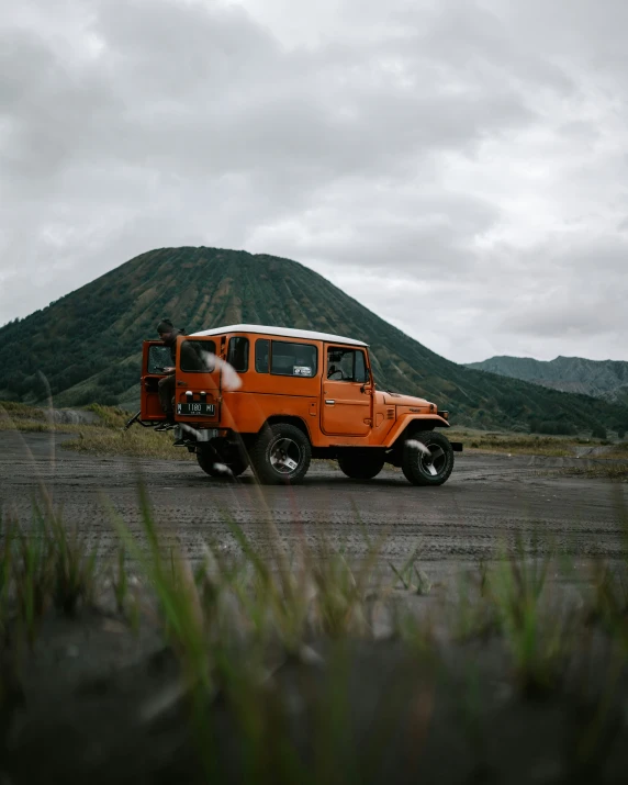 a jeep is parked in the middle of a gravel road