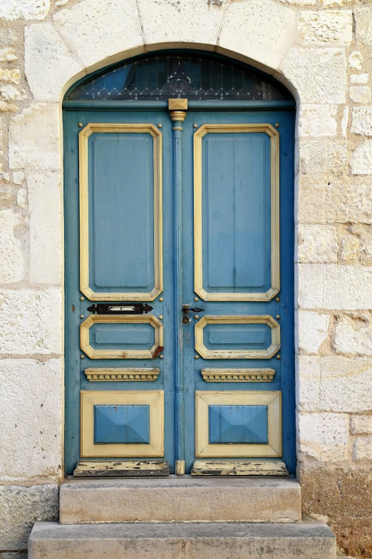 a very old blue door with some gold trim