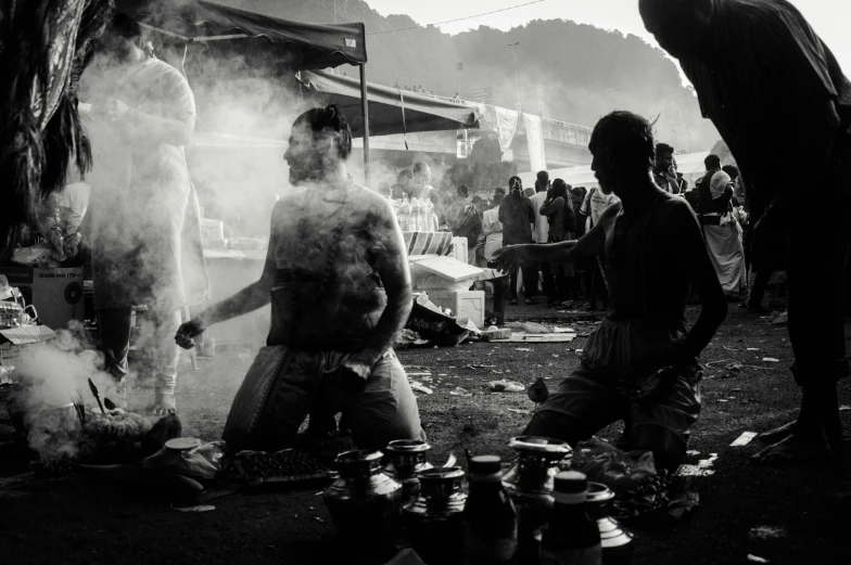 people are gathered around with cooking in the dark