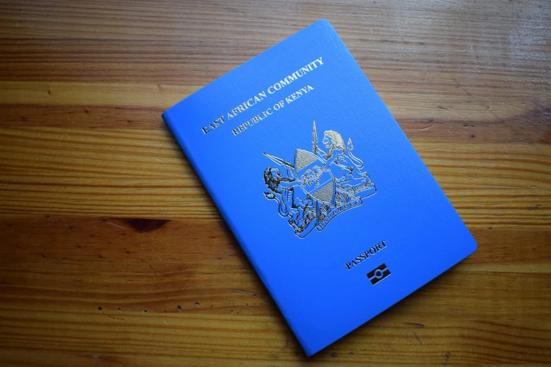 a blue passport on a wood surface